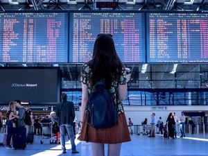 lady at airport looking at the arrival departure board