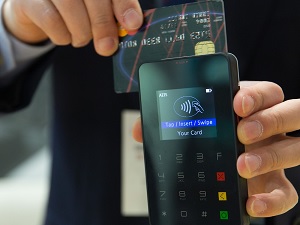 man holding a credit card processor while inserting a credit card