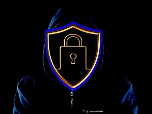 silhouette of a hacker with the face is a shield with a lock on it