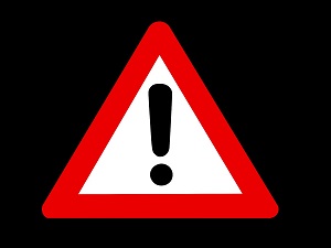 Red caution sign with a black exclamation point in the center with a black background