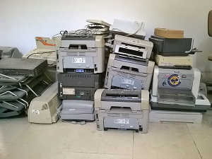 stack of old used laptops approximately 20 different printers in the stack