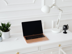 Gold laptop sitting on a white desk