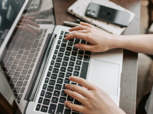 person typing on a laptop keyboard