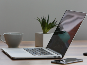 Open laptop on desk with cellphone next to it