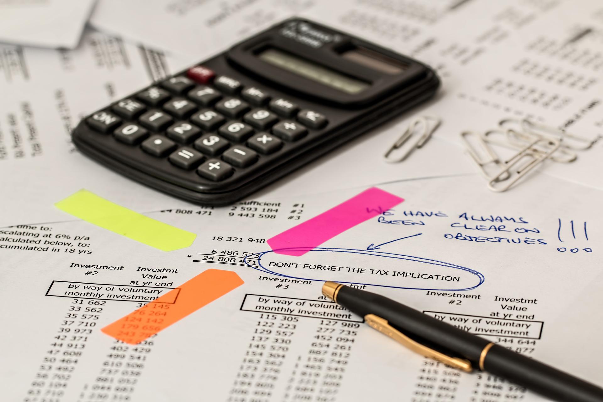 Calculator laying on tax preparation papers used by accountants and financial institutions